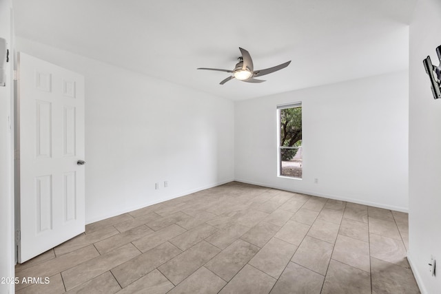 tiled empty room with a ceiling fan