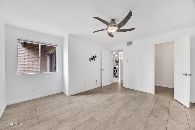 unfurnished room with ceiling fan, light tile patterned floors, and baseboards
