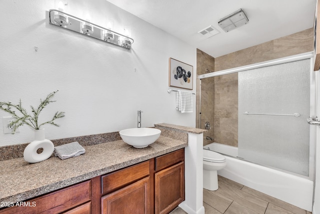 bathroom featuring toilet, vanity, and bath / shower combo with glass door