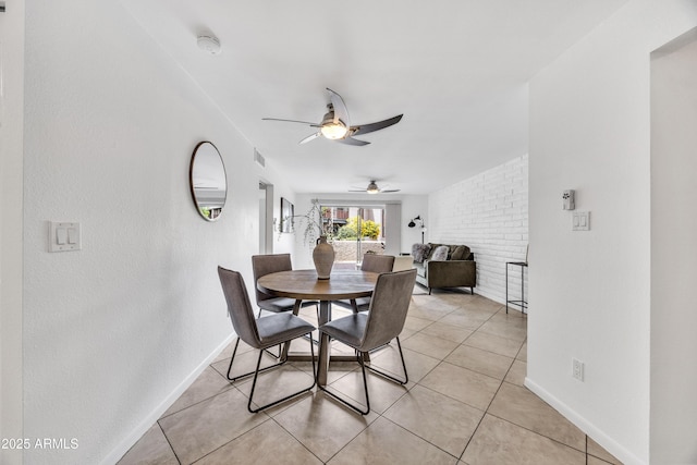 dining space featuring ceiling fan, baseboards, and light tile patterned floors