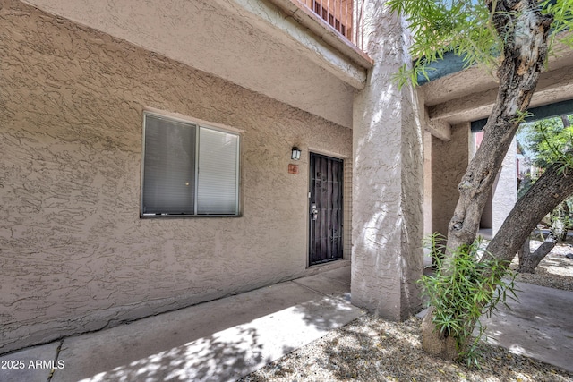 view of exterior entry with stucco siding