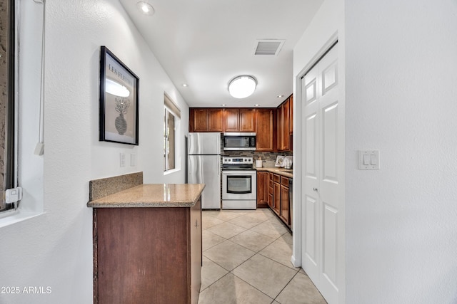 kitchen with stainless steel appliances, light tile patterned floors, and tasteful backsplash