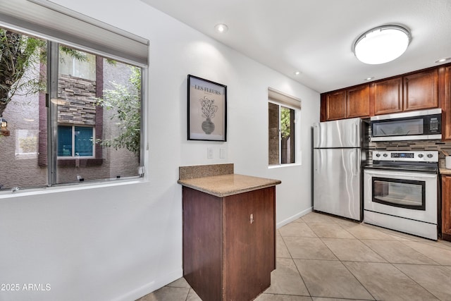 kitchen featuring appliances with stainless steel finishes, baseboards, light tile patterned floors, and recessed lighting