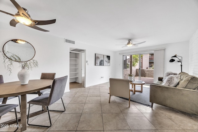 living area with ceiling fan and tile patterned flooring