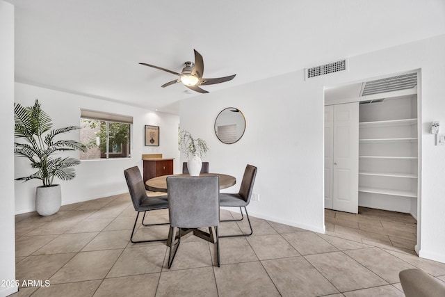 dining area with a ceiling fan, light tile patterned flooring, and baseboards