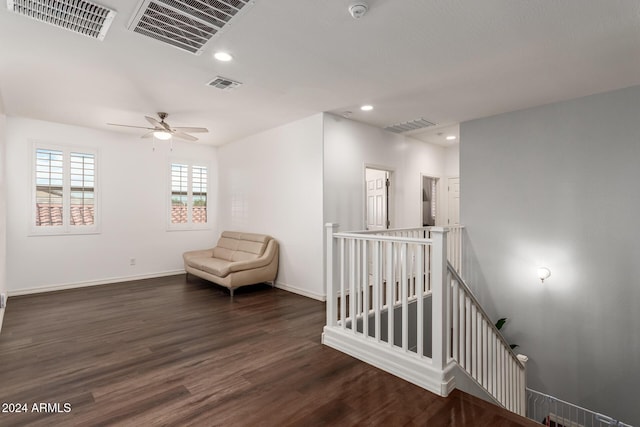 living area with ceiling fan and dark wood-type flooring