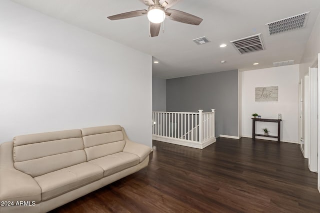 living room featuring ceiling fan and dark hardwood / wood-style floors