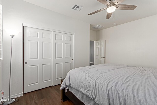 bedroom featuring dark hardwood / wood-style floors, ceiling fan, and a closet