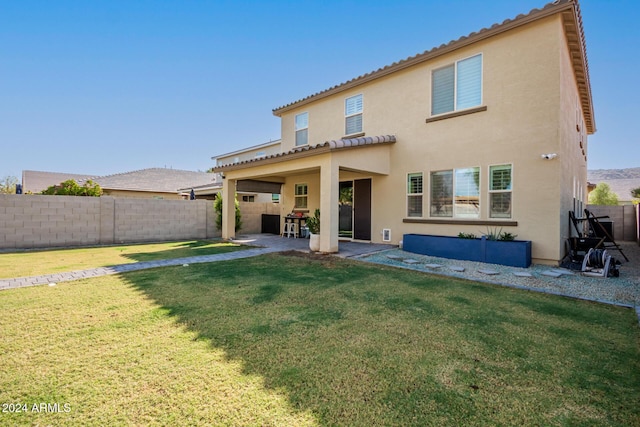 back of property with a yard and a patio area