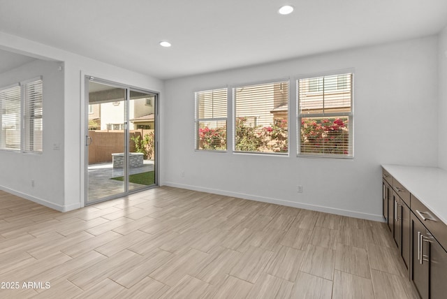 unfurnished room with light wood-type flooring, baseboards, and recessed lighting