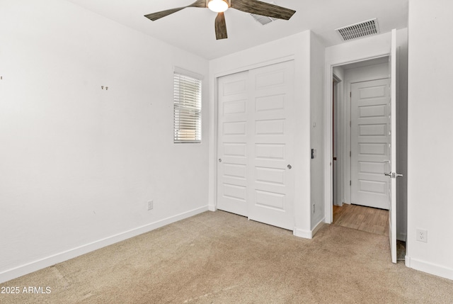 unfurnished bedroom with baseboards, a closet, visible vents, and light colored carpet