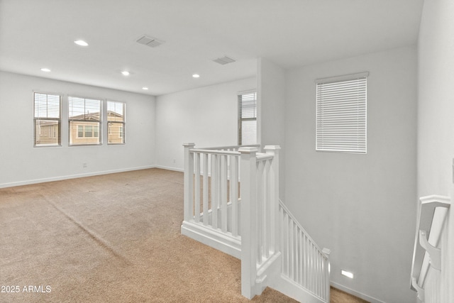 spare room featuring recessed lighting, carpet flooring, visible vents, and baseboards