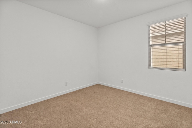 unfurnished room with light colored carpet and baseboards