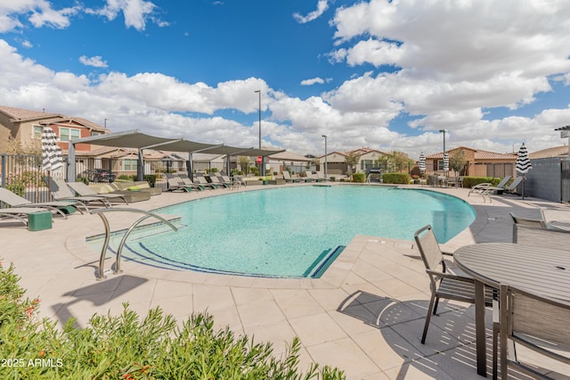 pool featuring a patio, fence, and a residential view