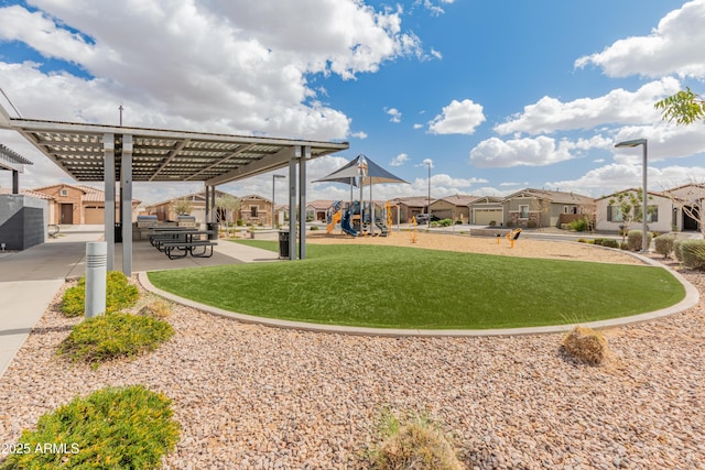 view of community with a residential view, a pergola, playground community, and a yard