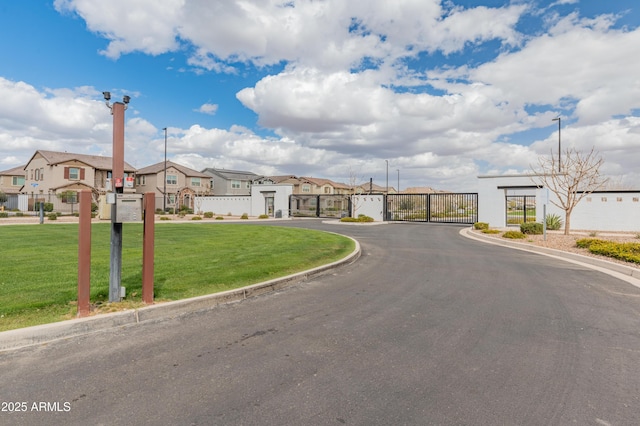 view of street with a residential view, a gate, curbs, and a gated entry