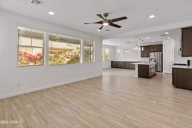 unfurnished living room featuring ceiling fan, baseboards, visible vents, and recessed lighting