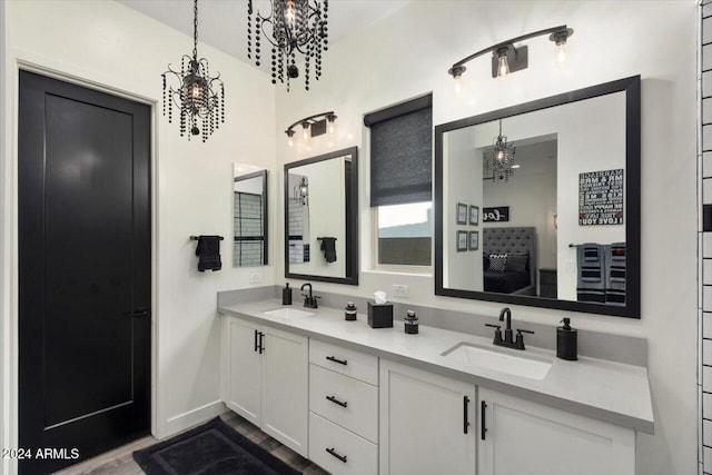 20428 W Elm Dr, Buckeye, AZ 85396 - full bathroom with a chandelier, double vanity, baseboards, and wood finished floors