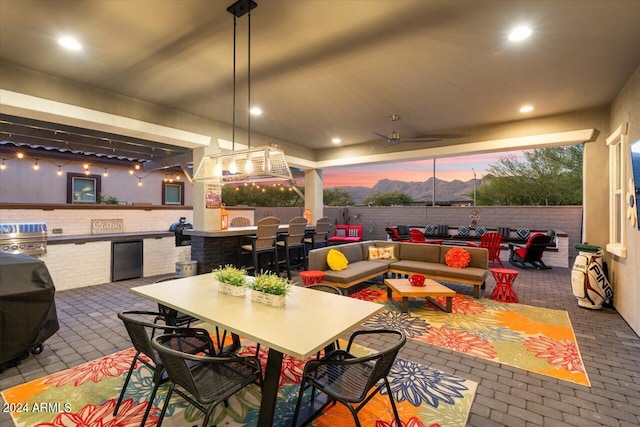 exterior space featuring outdoor lounge area, ceiling fan, and exterior kitchen