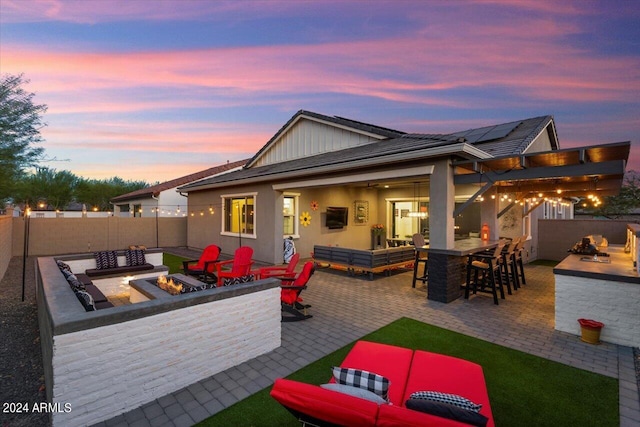 20428 W Elm Dr, Buckeye, AZ 85396 - rear view of house with an outdoor living space with a fire pit, a patio area, a fenced backyard, and exterior bar