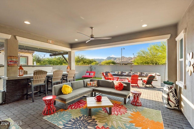 view of patio / terrace featuring a mountain view, an outdoor hangout area, ceiling fan, and a bar