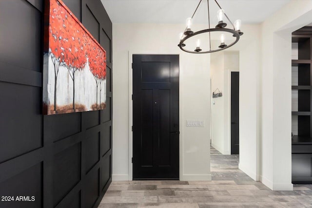 foyer entrance featuring a chandelier and light hardwood / wood-style flooring