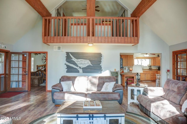 living area with ceiling fan, visible vents, and wood finished floors