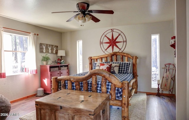 bedroom featuring ceiling fan, wood finished floors, and baseboards