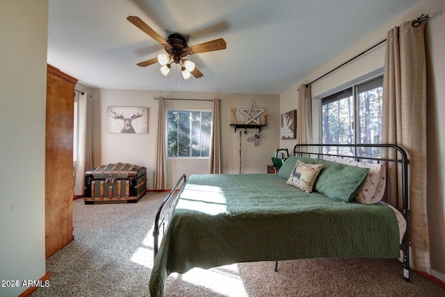 carpeted bedroom featuring multiple windows and ceiling fan