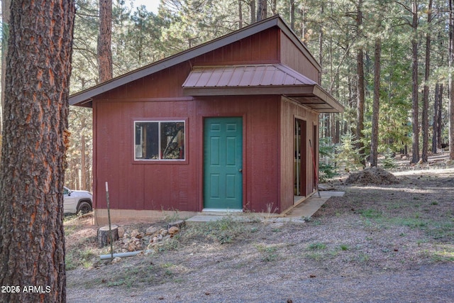 view of outbuilding with an outbuilding and a view of trees