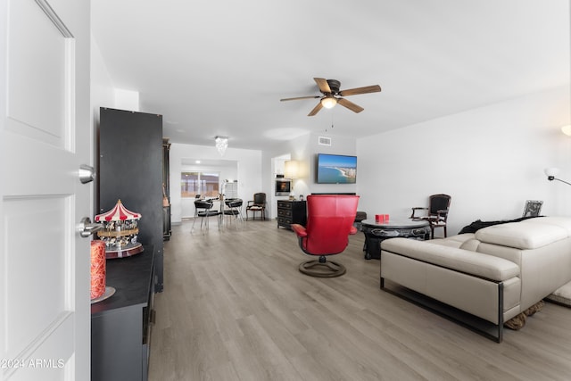 living room featuring light wood-type flooring and ceiling fan