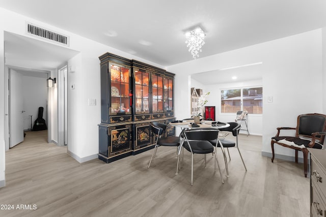 dining area with a chandelier and light hardwood / wood-style flooring