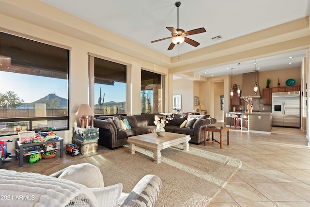 living room with ceiling fan, a mountain view, and light tile patterned floors