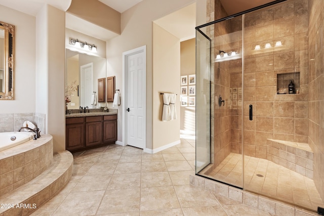 bathroom featuring tile patterned flooring, shower with separate bathtub, and vanity