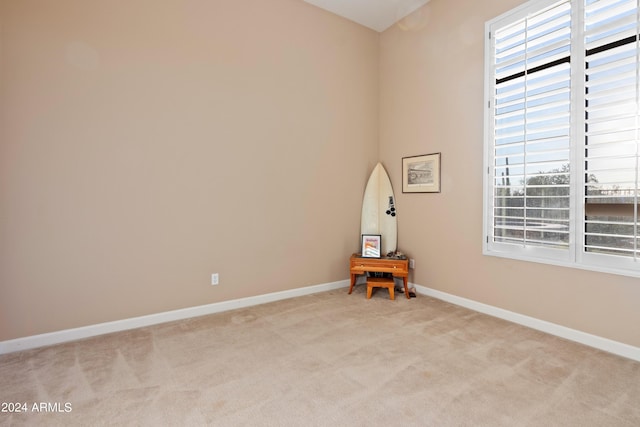 empty room featuring plenty of natural light and light colored carpet