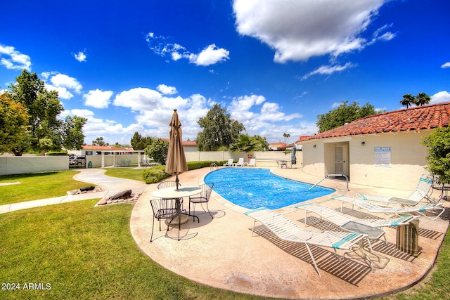 view of swimming pool with a patio and a yard