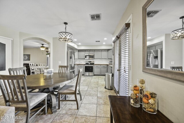 dining room with light tile patterned floors, visible vents, ceiling fan with notable chandelier, and recessed lighting
