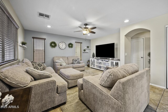 living area with visible vents, recessed lighting, arched walkways, baseboards, and ceiling fan