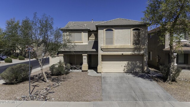view of front of home featuring a tile roof, concrete driveway, an attached garage, and stucco siding