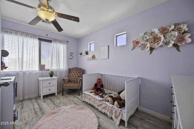 bedroom with a ceiling fan, baseboards, and wood finished floors