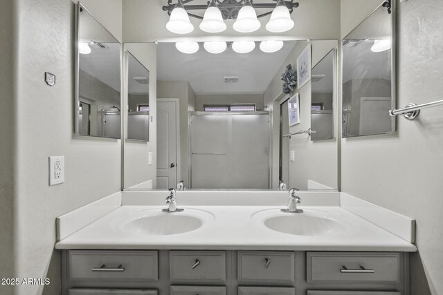 bathroom featuring double vanity, an enclosed shower, and a sink