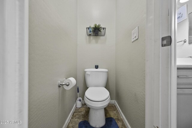 bathroom featuring toilet and baseboards