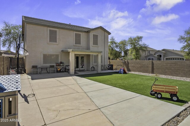 rear view of house with a patio area, stucco siding, french doors, and a fenced backyard