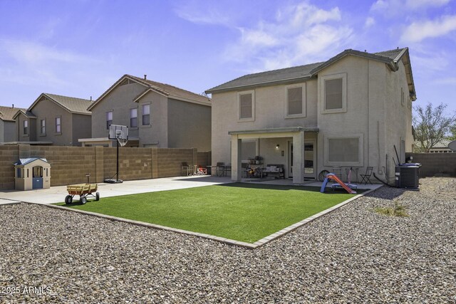 rear view of property featuring fence, central AC unit, stucco siding, a yard, and a patio area