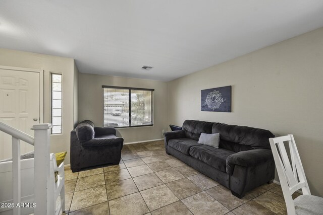 living area with light tile patterned flooring, visible vents, and baseboards