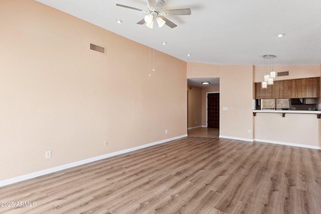 unfurnished living room featuring ceiling fan and light wood-type flooring