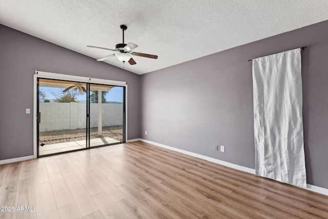 unfurnished room with vaulted ceiling, a textured ceiling, ceiling fan, and light hardwood / wood-style floors