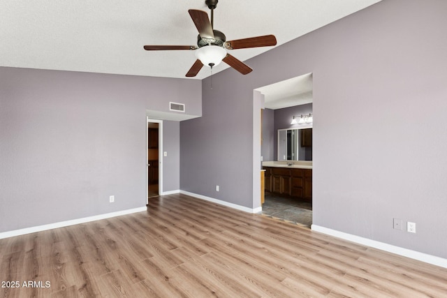 interior space featuring ceiling fan, vaulted ceiling, and light wood-type flooring