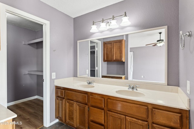 bathroom featuring vanity, wood-type flooring, a textured ceiling, and ceiling fan