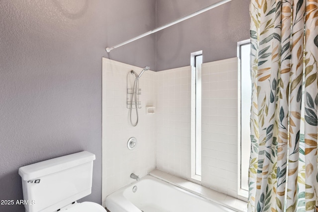 bathroom featuring shower / bath combination with curtain and toilet